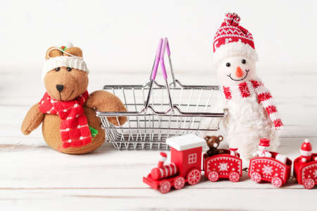 New Year, Christmas sales concept. New Year's toys near the shopping basket on a white background.の写真素材