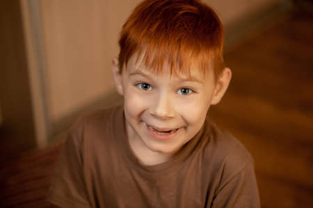 Redheaded young boy smiling for the camera at home.の写真素材