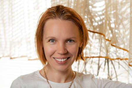 Attractive woman in her forties smiling for the camera at home.