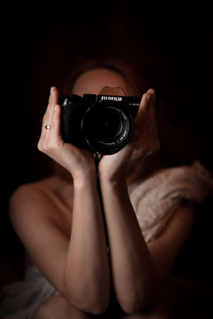 Kiev, Ukraine - November 10, 2021: Fujifilm XS-10 camera in the hands of a woman on a black...
