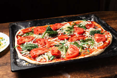 Vegetarian pizza close-up on a baking sheet. Cooking delicious homemade pizzaの写真素材