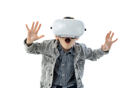 Young boy with virtual reality glasses isolated on white background. A child in emotional excitement...