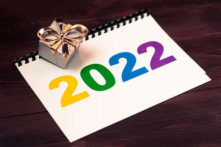 2022 multicolored numbers on a piece of paper and a gift lying.