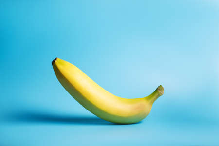 One yellow banana on a blue background.