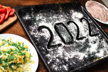 2022 numbers on flour on a baking sheet. New year culinary concept.の写真素材