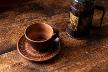 Empty clay tea cup. Dark wooden background. Teapot with herbal tea. Healthy herbal tea.の写真素材