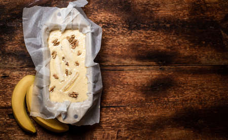 Banana bread. Cooking. Vegetarian food. Cupcake with bananas and nuts on a wooden background. Place for your text.の写真素材