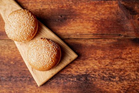 Hamburger buns. Sesame seeds on top. wooden background. food concept. Place for text.