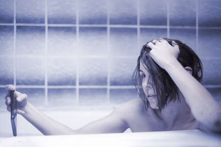 Sensual middle-aged woman takes a bath and communicates on a mobile phone by video communication. Nude selfie, intimate photo concept. Online dating, love games. blue tone.の写真素材