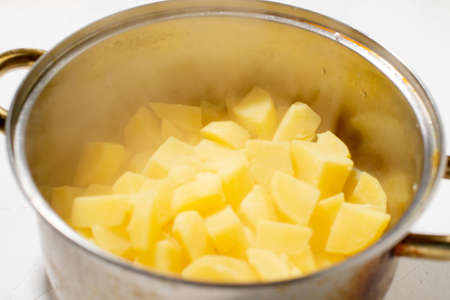 Boiled potatoes in a pot. Hot potato cubes with a piece of butter. Cooking boiled potatoes, mashed...