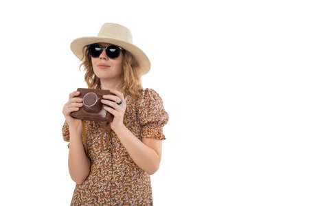 Woman in sunglasses, brown dress in hat with retro camera isolated on white background.の写真素材
