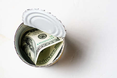 Dollars in an open tin can. Safe guarding cash, stash concept. Time to get the deferred, accumulated...
