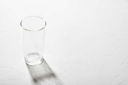 Empty glass beaker on a white background. Clear shadow, hard light.の写真素材