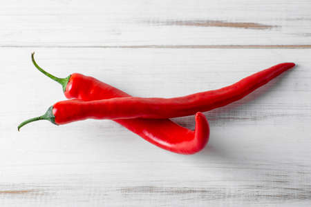 Red hot chili peppers on a white wooden background.