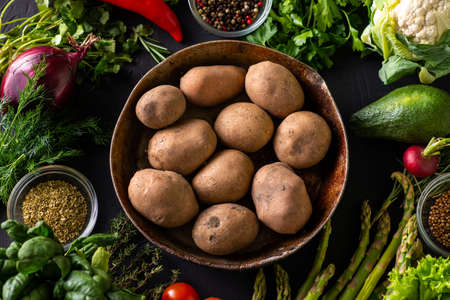 Raw potato tubers. Various vegetables around. Vegetarian foodの写真素材