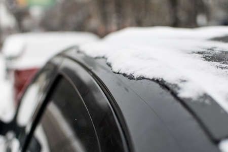 Snow on a black car.の写真素材