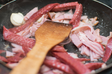 Fry the sliced sausage in the pan.の写真素材