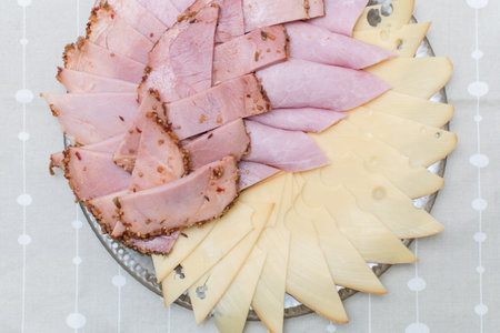 Sliced sausage, ham and cheese on a plate.の写真素材