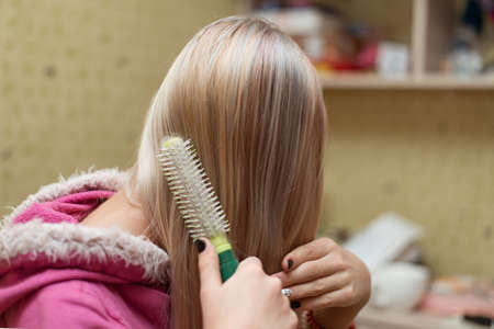 Teen girl combing her hair.