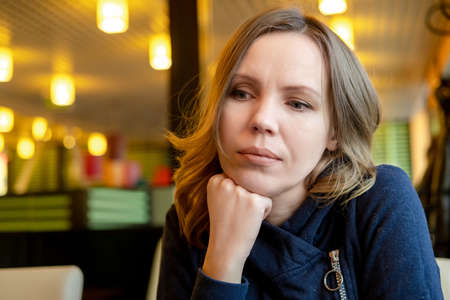 Sad adult woman in a cafe. Depression, crisis.