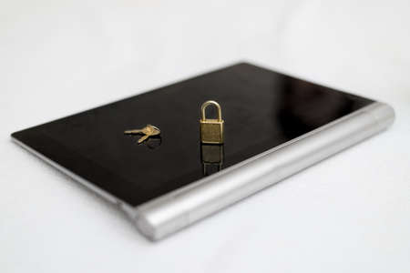 Electronic security and data protection concept. Tablet computer and lock with keys.の写真素材