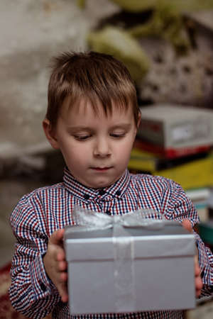 A little boy is holding a box with a gift.の写真素材