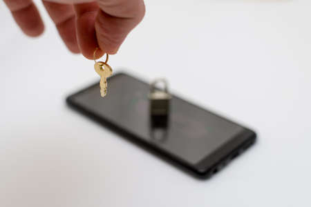 Electronic security and data protection concept. mobile phone and key lock.の写真素材