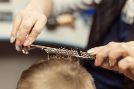 Little boy does a haircut at the hairdresser. baby hair care.の写真素材