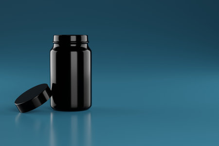 Black container for tablets, pills on a blue background. Place for text.の写真素材
