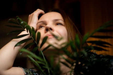 Woman relaxing at home in plants. an attractive woman of forty years of age. Home recovery, rest.の写真素材