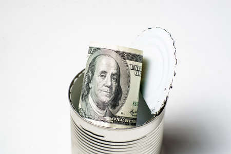 Dollars in an open tin can. Safe guarding cash, stash concept. Time to get the deferred, accumulated...