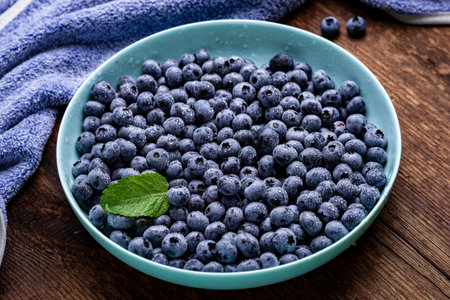Fresh blueberries berries in a plate on a dark wooden background.の写真素材