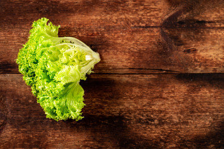 Green lettuce salad on a wooden background. Vegetarianism concept, plant food. Place for text.の写真素材