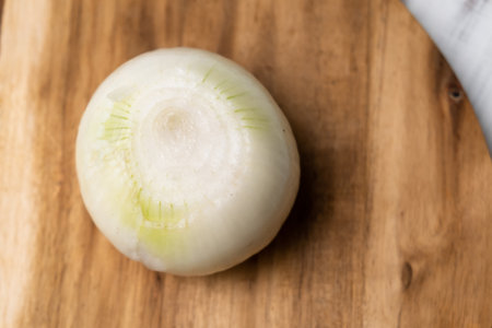 Whole onion peeled on a wooden board. Preparation for cooking.の写真素材