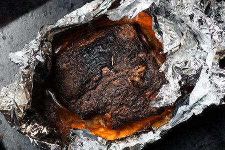 A piece of meat baked in the oven in foil. Home cooking.の写真素材