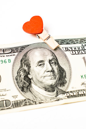 Dollar and a heart on a white background. Love for money, donations concept.の写真素材