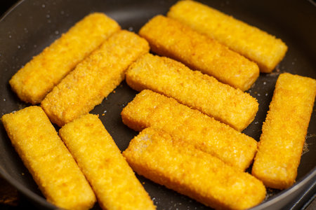 Fish sticks in a pan. Preparation of frozen fish sticks. fast food.の写真素材