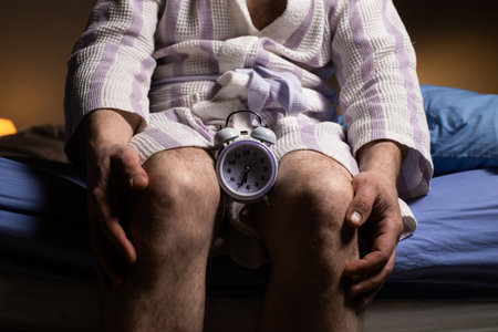 Andropause concept. Alarm clock between male legs. Male menopause, impotence, biological clock.の写真素材