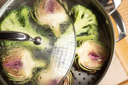 Artichoke purple halves and broccoli in a double boiler. Steaming vegetables. Vegan healthy food, diet concept.の写真素材