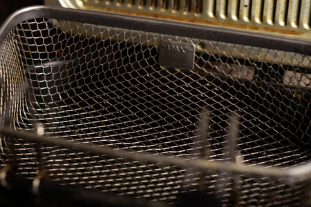 Empty dirty deep fryer basket. Preparation for cooking.