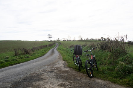 Two bicycles near rural road without people. Parked adult and children's bicyclesの写真素材