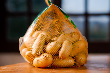Mesh bag with whole potatoes. Sale or purchase of potatoes.の写真素材