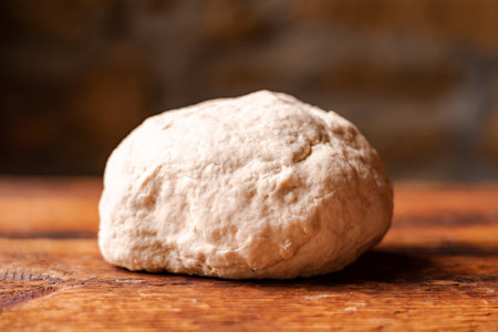 Yeast dough ball on wooden background. Cooked dough for baking pizza or bread.の写真素材