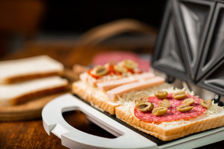 sandwich maker and cooking different sandwiches with sausage, cheese, sausages.の写真素材