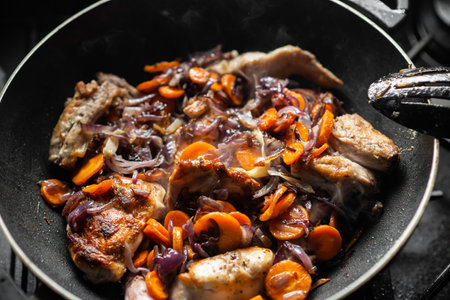 Raw rabbit with spices, onions and carrots in a frying pan. Cooking stewed rabbit.の写真素材
