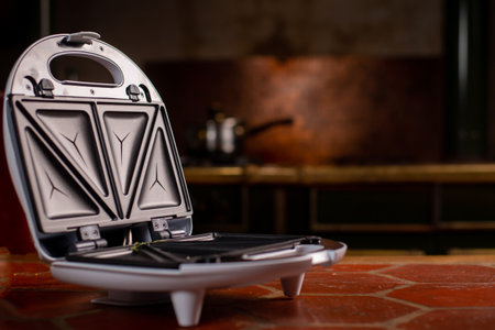 Open empty sandwich maker in the kitchen. Preparation for cooking. Place for text.の写真素材