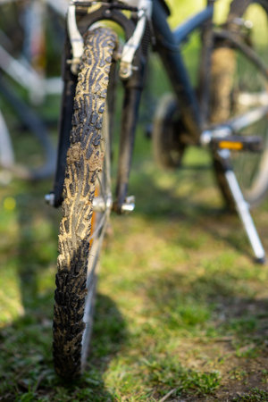Dirty bike wheel. Bicycle rides, travel, outdoor activities. The bike is on the green grass.の写真素材