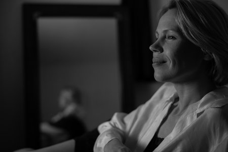Woman in pleasant thoughtfulness. A middle-aged woman looks away smiling. Calm, peaceful atmosphere, rest and relaxation. black and white photo.の写真素材