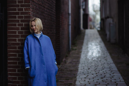 Weekend in the Netherlands, a woman in a blue coat on the background of the streets of the city. Rest, travel in Europe.の写真素材