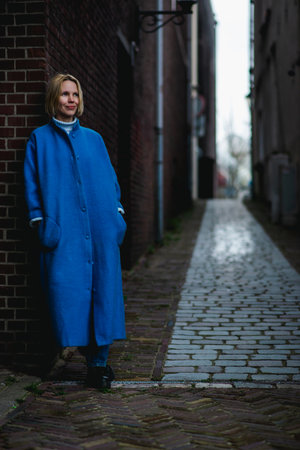 Weekend in the Netherlands, a woman in a blue coat on the background of the streets of the city. Rest, travel in Europe.の写真素材